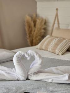 Dos serpientes de toalla formando un corazón en una cama en Un moment de détente, en Gilly-sur-Isère