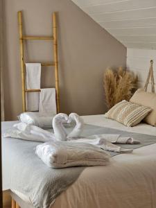 dos cisnes sentados en la parte superior de una cama con toallas en Un moment de détente, en Gilly-sur-Isère