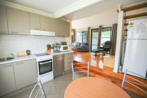 a kitchen with white appliances and a wooden floor at Allambie Cottages - Villa 1 in Bright