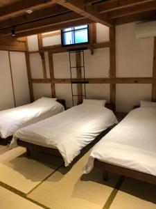 three beds in a room with a tv on the wall at Kuroishi - House - Vacation STAY 87006 in Kuroishi