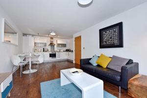 a living room with a couch and a table at The Vizion serviced apartments from Pincott Properties - free parking, private balcony, and WiFi in Milton Keynes