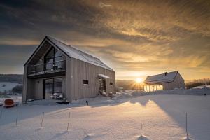 stodoła w śniegu z zachodem słońca w tle w obiekcie Bieszczadzka Stodoła w mieście Ustrzyki Dolne