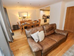 uma sala de estar com um sofá castanho e uma sala de jantar em Goldfinch em Milford Haven