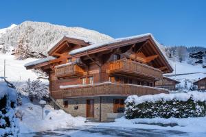 una cabaña de madera en invierno con nieve en Chalet Alia and Apartments-Grindelwald by Swiss Hotel Apartments, en Grindelwald