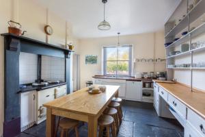 a large kitchen with a wooden table and chairs at The Old Rectory in Bristol
