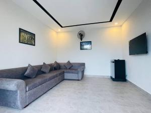 The Square Residence في كامبوت: غرفة معيشة مع أريكة وتلفزيون بشاشة مسطحة