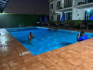 zwei Männer in einem Schwimmbad in einem Hotel in der Unterkunft Cromer Apartments in Accra