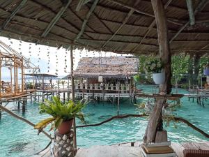 een resort met een bos tafels en water bij Yenbainus homestay in Yennanas Besir