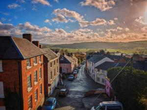 a small town with cars parked on a street at The Castle Hotel in Bishops Castle