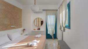a white room with a bed and a mirror at Skarmoutsos Holiday Home in Vourvoúlos