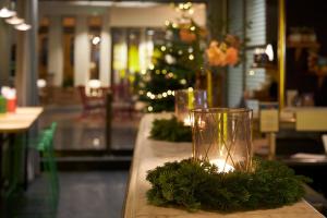 a glass vase sitting on a table with a christmas tree at Hotel Lundia in Lund