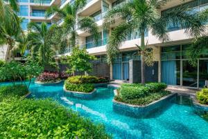 a hotel courtyard with blue water and palm trees at MGM Grand Sanya in Sanya