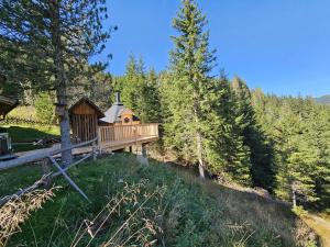 a cabin with a deck in the woods at Almhaus Zirbenheim Nicolina in Flattnitz