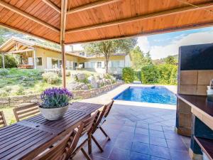 un patio con mesa y sillas y una piscina en Villa Encina en Aiguafreda en Aiguafreda
