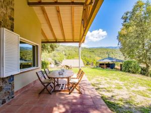 un patio con tavolo e sedie su una casa di Villa Encina en Aiguafreda ad Ayguafreda
