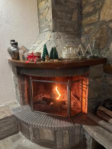 a stone fireplace with a fire in it at Urban River House in Florina