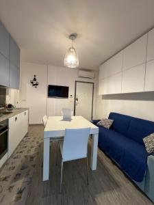 a kitchen and living room with a table and a blue couch at PM 10 Via Joan Mirò Guest House in Alghero