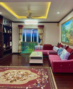 a living room with a red couch and a rug at Ngọc Phương Anh Homestay Huế in Hue