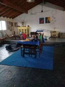 une salle à manger avec une table bleue et des chaises sur un tapis bleu dans l'établissement La casa de los murales, à Avellaneda