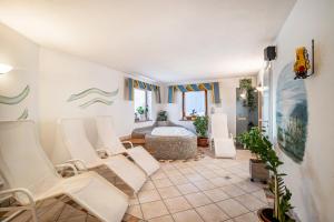 a living room with white chairs and a bath tub at App Hubertus - Sonnklar in Sand in Taufers