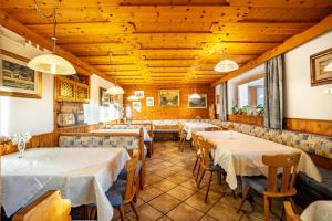 un restaurante con mesas, sillas y techos de madera en App Hubertus - Wasserfallspitz, en Sand in Taufers
