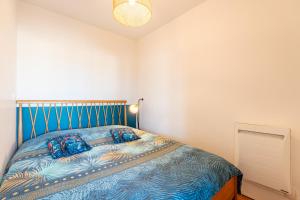 Schlafzimmer mit einem Bett mit blauem Kopfteil in der Unterkunft La station n° 5 in Annecy