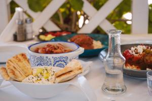 una mesa con un tazón de comida y un tazón de pan en Faedra Beach, en Agios Nikolaos
