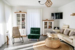 a living room with a couch and a green chair at Park-Apartment Scharmützelsee Wohnung 5 in Wendisch Rietz