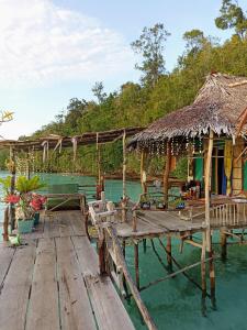 een houten steiger met een hut op het water bij Yenbainus homestay in Yennanas Besir