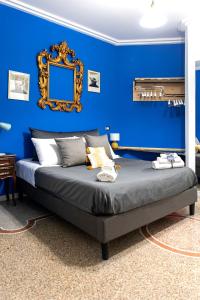 a blue bedroom with a bed with a mirror on the wall at Miracolo al Duomo Smart Accomodations in Naples