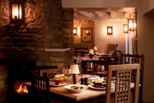 un comedor con una mesa con comida. en The Three Horseshoes en Burford