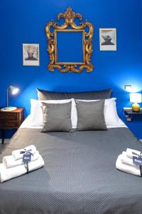 - une chambre bleue avec un lit et un miroir mural dans l'établissement Miracolo al Duomo Smart Accomodations, à Naples