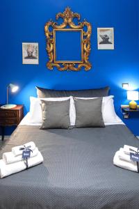 a blue bedroom with a bed with a mirror on the wall at Miracolo al Duomo Smart Accomodations in Naples