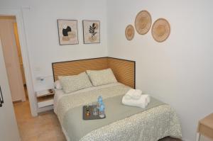 Schlafzimmer mit einem Bett und einem Tablett mit Handtüchern in der Unterkunft Alojamiento Azahara in Málaga