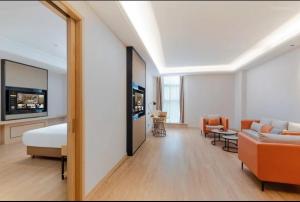 een hotelkamer met een bed en een woonkamer bij Vienna International Hotel Shenzhen Baolong subway Station branch in Longgang