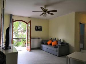 uma sala de estar com um sofá e uma ventoinha de tecto em D19 em Peschiera del Garda