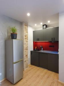 a kitchen with a refrigerator and a red wall at New apartment in historic house in Riga