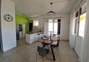 a kitchen and dining room with a table and chairs at Maïlly - Charmante villa T5 in Capesterre-Belle-Eau