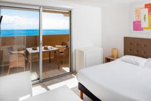 1 dormitorio con cama y vistas al océano en Résidence Marina Bianca, en Santa-Lucia-di-Moriani