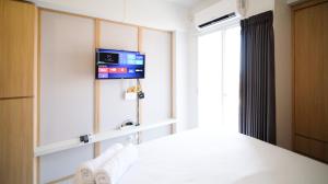 a room with a tv on the wall at Studio Apartment at Suncity Residence Sidoarjo near Suncity Mall By Travelio in Sidoarjo +9 photos