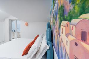 a bedroom with a painting on the wall at Albergo Dipinto BaccoFurore in Furore