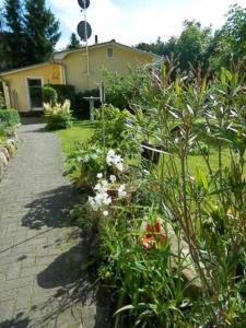 a garden with flowers in front of a house at Heidtschmidhof Gästehaus in Wolgast