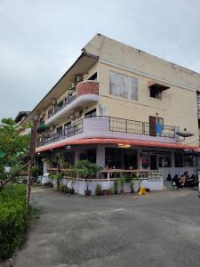 a building with people sitting outside of it at 2 Vikings Guesthouse in Karon Beach