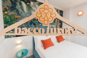 a wooden sign in a room with a bed at Albergo Dipinto BaccoFurore in Furore