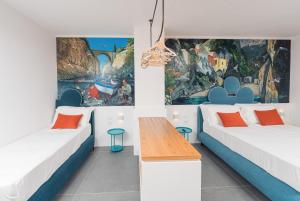 a room with two beds with orange and blue pillows at Albergo Dipinto BaccoFurore in Furore