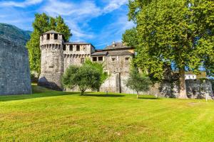 un vieux château avec un champ de pelouse devant lui dans l'établissement Amazing Lugano - Happy Rentals, à Lugano