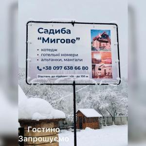 a sign in the snow next to a building at Садиба Мигове in Migovo