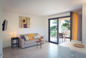 una sala de estar con un sofá y una mesa en Résidence Marina Bianca, en Santa-Lucia-di-Moriani
