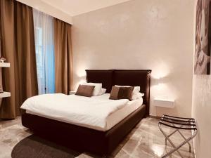 Schlafzimmer mit einem Bett mit weißer Bettwäsche und Kissen in der Unterkunft DolceVitaSuite in Rom