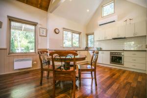 a kitchen with a table and chairs in a room at Alpine Arnica Cottage 1 in Harrietville